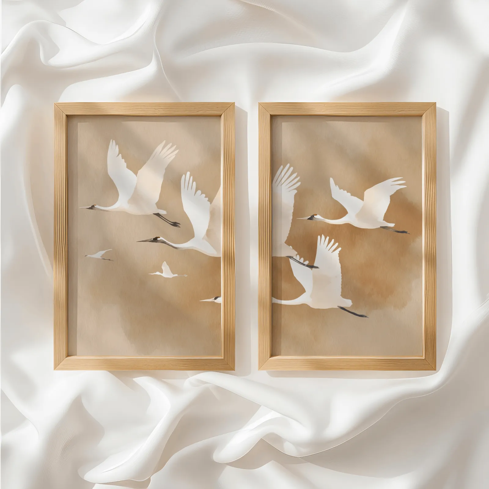 beige crane wall art set of two, side by side atop rumpled white silky fabric